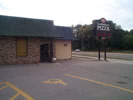 A Godfathers Pizza restaurant in Sioux City, IA. The outside of the building consists of brown and black bricks and tan siding.
