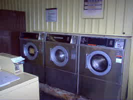 Washing machines at a laundromat, two of three missing door handles