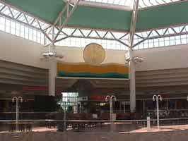 The food court sign of the Oak View Mall. The neon sign is unlit, and overlooks the seating area.