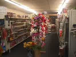 A toy aisle with tall flowers standing on a shelf in the middle.