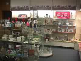 An aisle of house goods, with glass shelves holding mugs and signs.