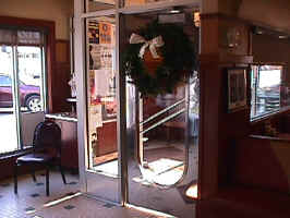 The inner door of the Philips Avenue Diner. The door is shiny silver, and has an oval window in the middle.