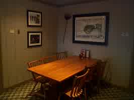 An empty dining table, with an illustration of an old tractor on the wall