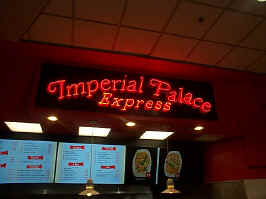 The sign for Imperial Palace Express, a Chinese food stand in the mall. The sign is made of red neon, spelling out the name in a cursive serif font.