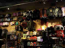 A wall of the Hot Topic. The wall is lined with skirts, jackets, and handbags. Racks of various merch are visible in the shot.