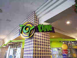 The sign for the Toy Time in the Crown Center Mall. The "TOY" is spelled in a wacky font on a yellow and purple spiral, with "time" in a playful sans-serif font.