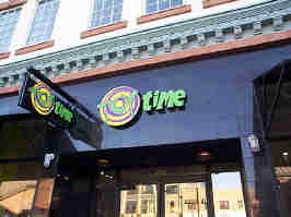 The Toy Time storefront in Zona Rosa. The front of the store is black tile above windows, with the company's wacky 2000's logo above glass doors.