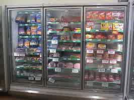 A freezer with meat and cheese products.