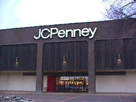 The outside storefront of the Empire Mall JCPenny's. Brick, dark wood, and white paint make up the storefront.