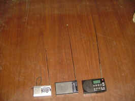 A photo comparing antenna lengths. The Indin BC-R22 is to the left with the shortest antenna, the Sony ICF-P26 is in the middle with a medium length antenna, and the Sangean HDR-14 is on the right with the longest antenna.